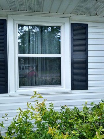 New vinyl window replacement with black shutters