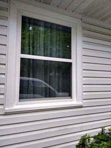 Vinyl window replacement and siding replacement for a white home