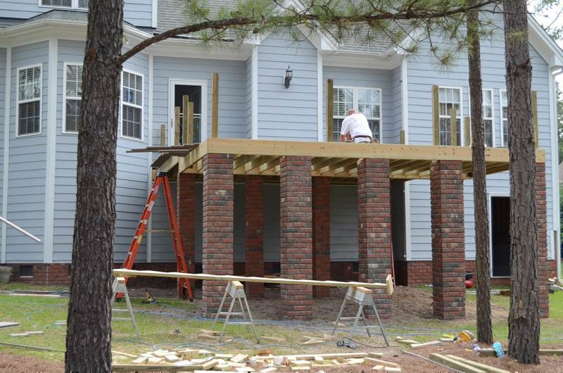 construction worker building new deck with brick footers