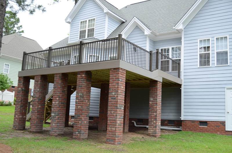 corner of new gray deck with brick footers