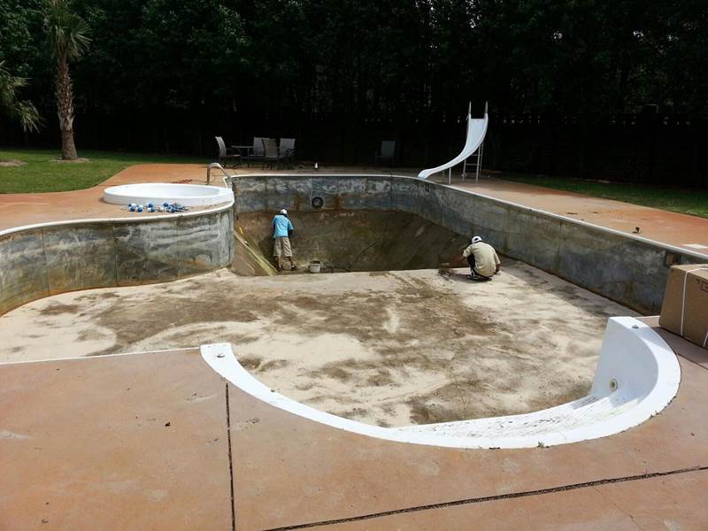 2 workers repairing inground pool