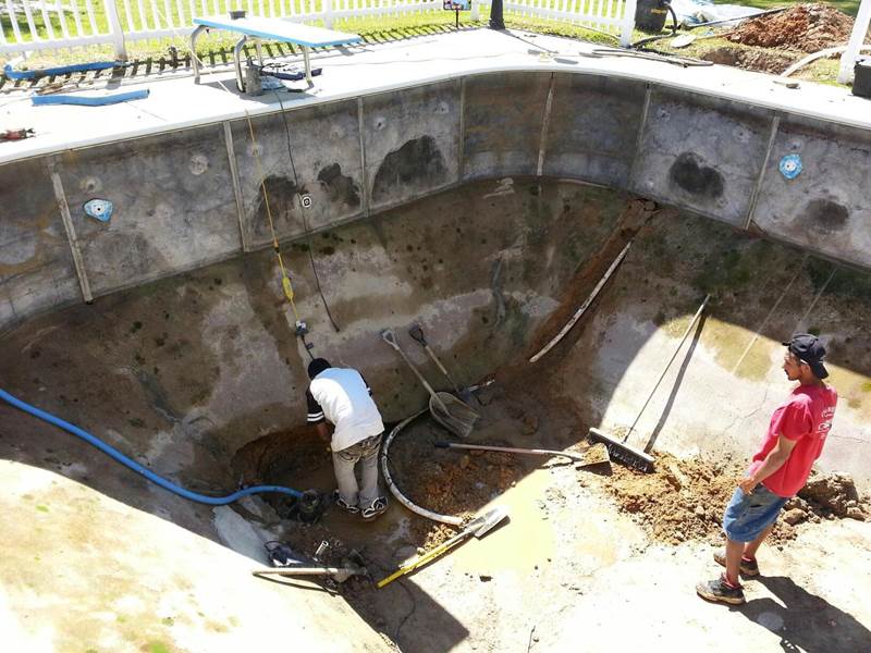 2 workers repairing inground pool