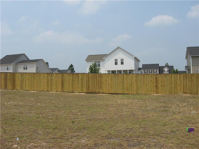 wooden fence around dirt field