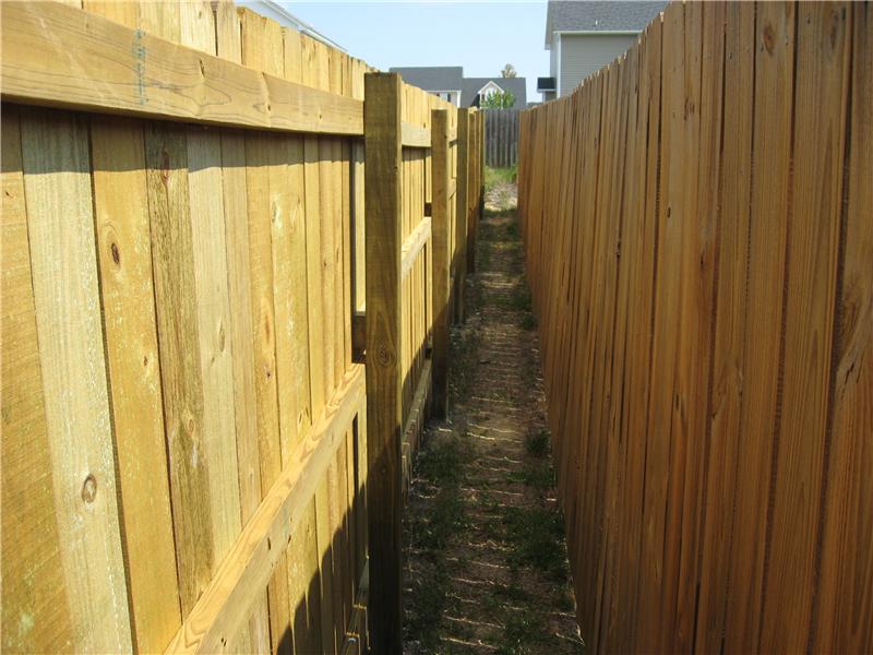 exterior view of board on board fence along side neighbor fence