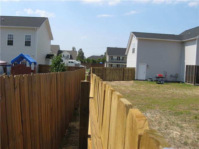 exterior view of board on board fence along side neighbors fence