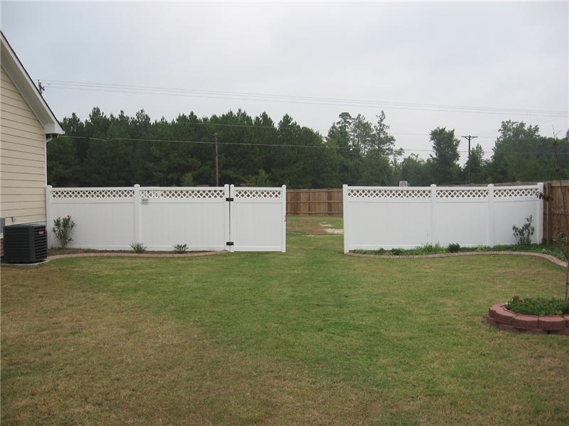 white vinyl board on board fence topped with lattice