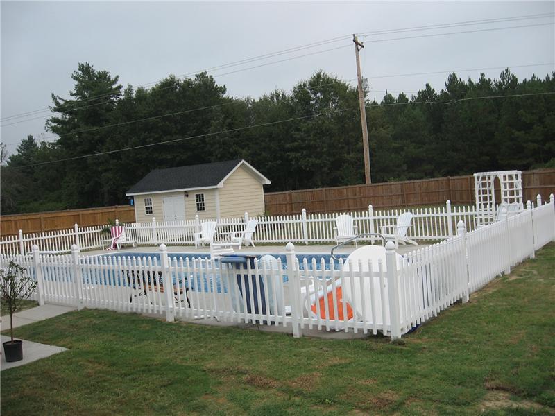 white vinyl picket fence surrounding pool