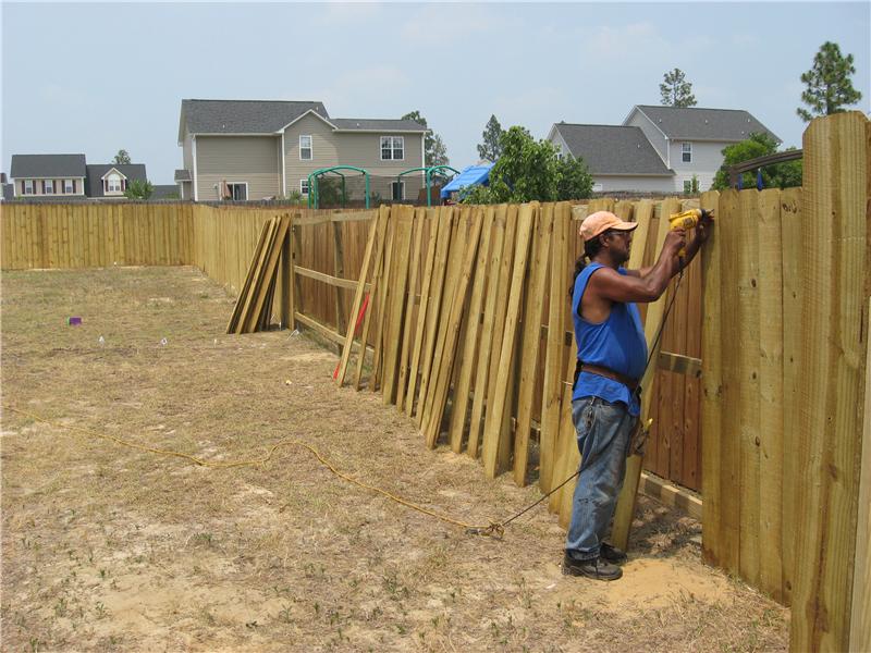 fence builder at work putting up posts