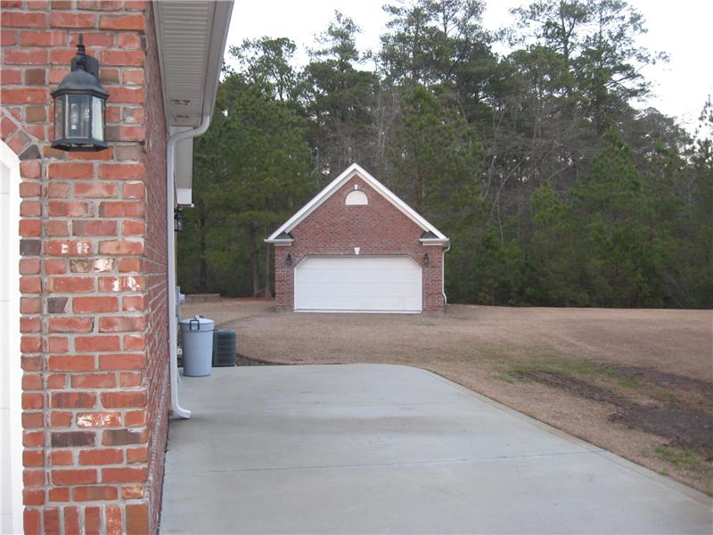 brick detached single car garage in back of house