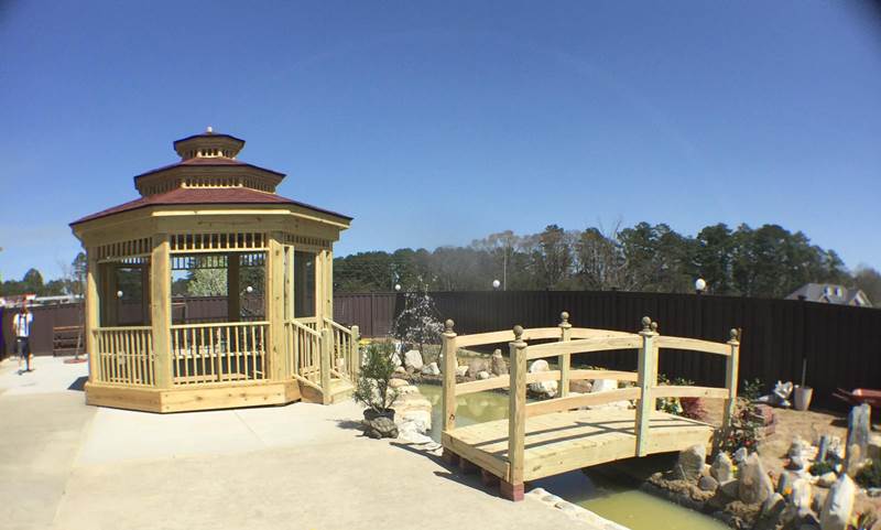 gazebo and wooden bridge in backyard landscape