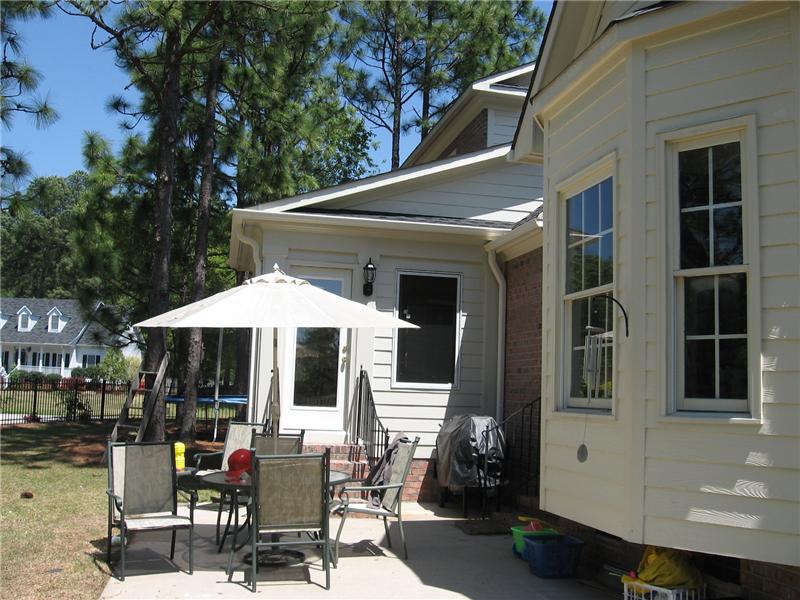 patio and side veiw of sunroom on brick house