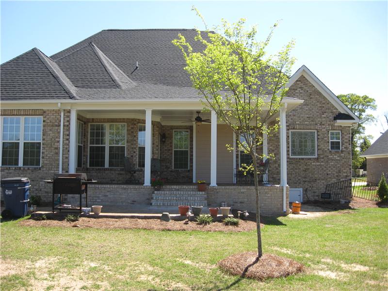 front porch with ceiling fan on brick house