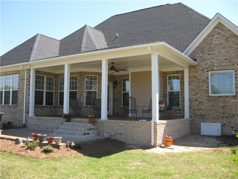 front porch with ceiling fan on brick house