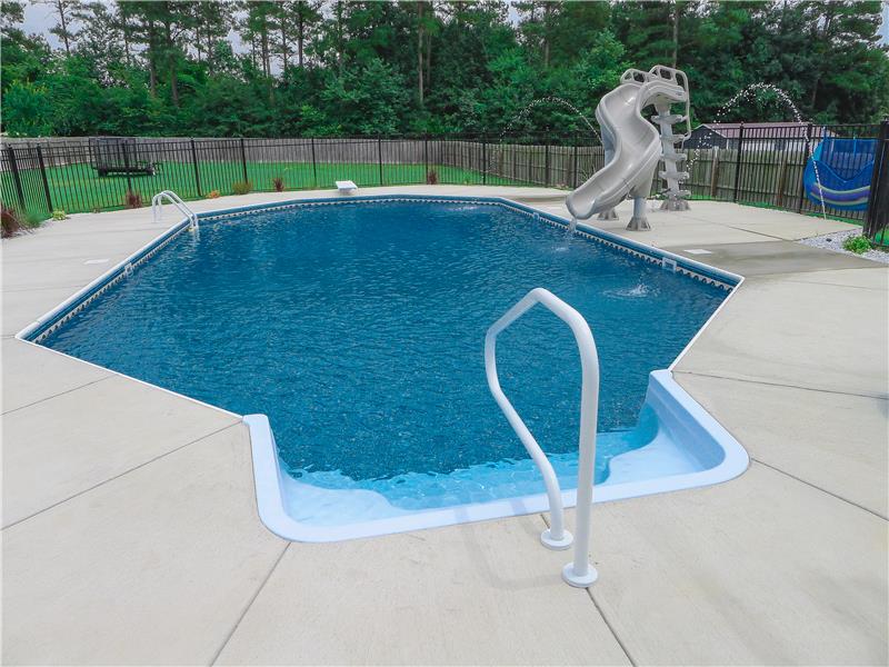 stair and railing leading into pool with slide