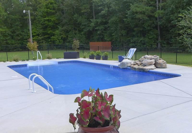 rectangular pool with fountain rock formation waterfall