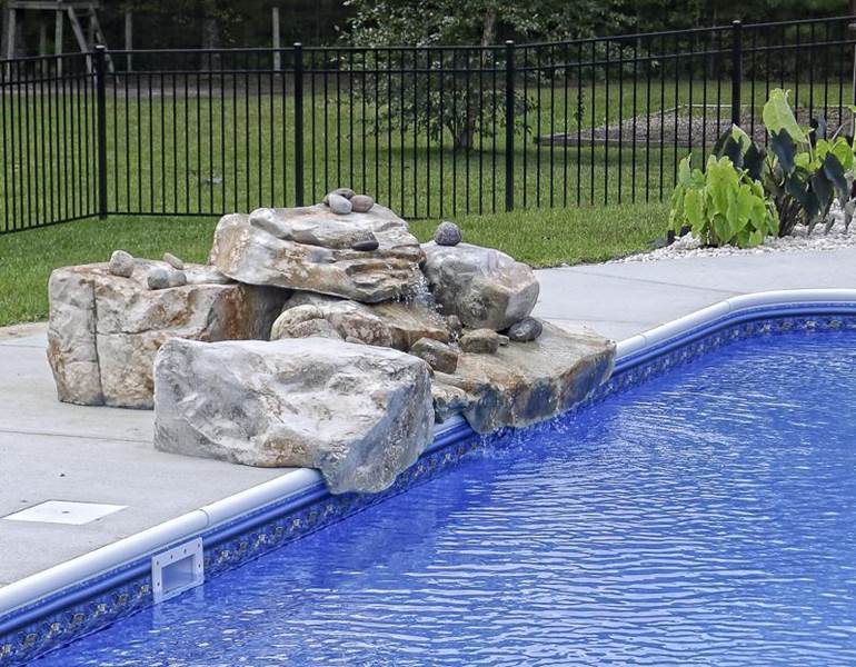 rock formation waterfall on edge of pool