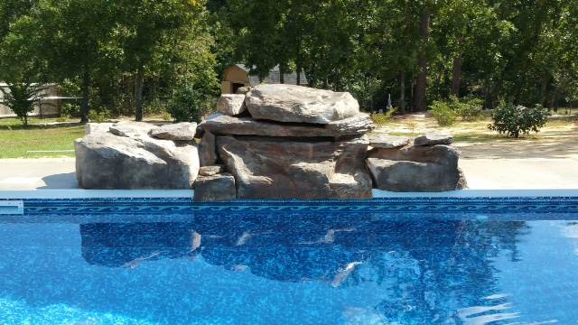 rock formation waterfall on edge of pool