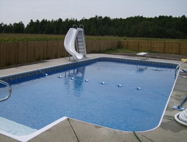 inground pool with slide and diving board