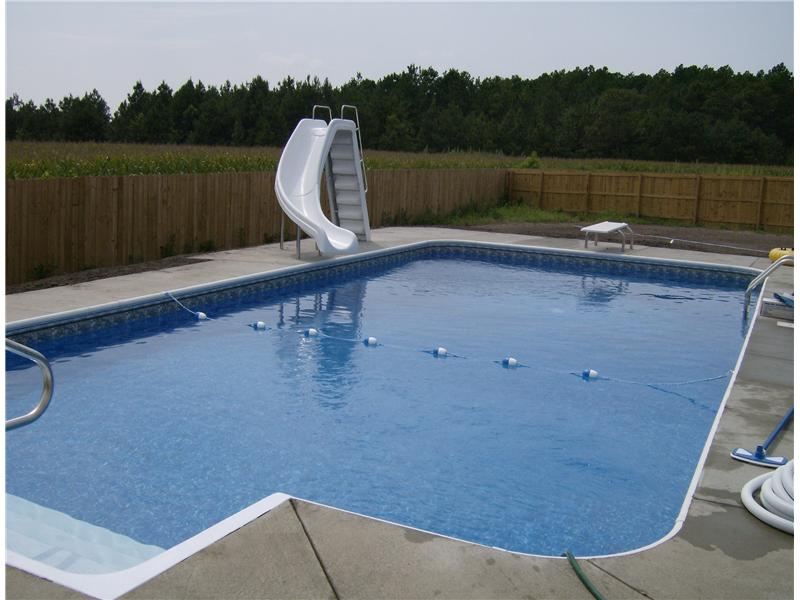 inground pool with slide and diving board