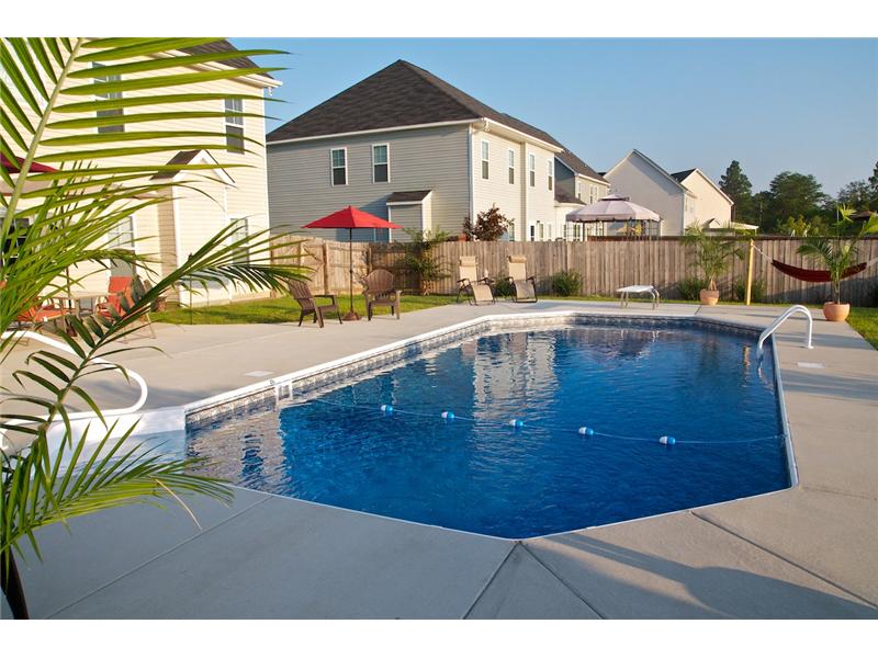 inground pool with chairs and plants on decking
