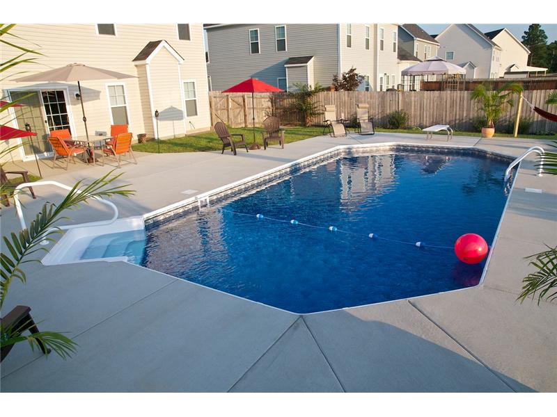 backyard with pool patio set and chair on cement decking