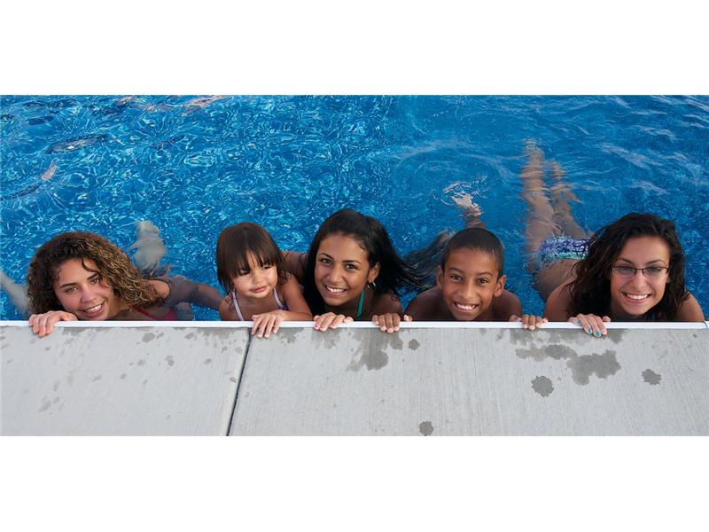 5 kids in water holding onto the edge of pool