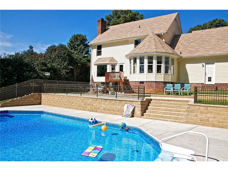 inground pool with back of house in background