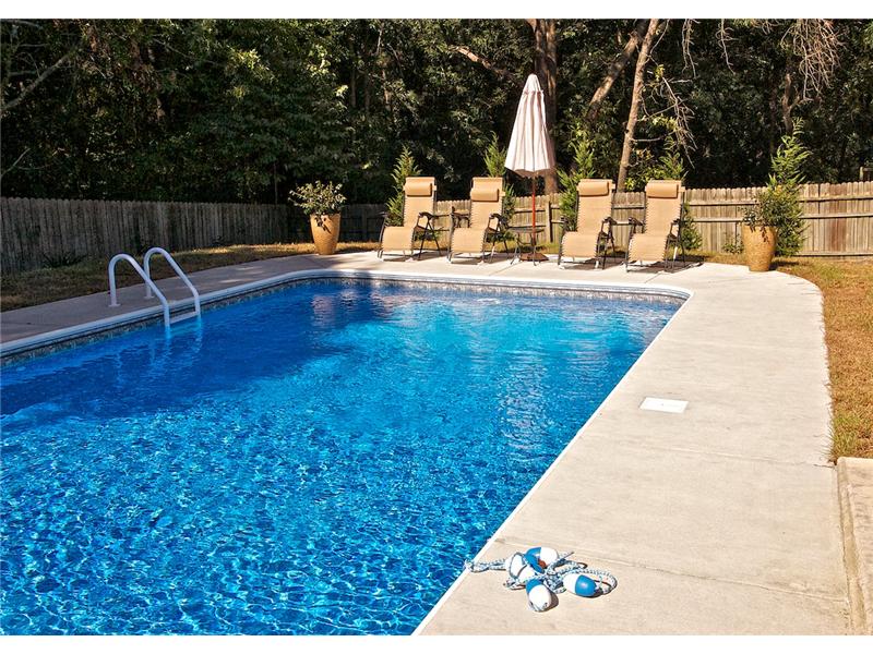 pool with lounge chairs and umbrella in background