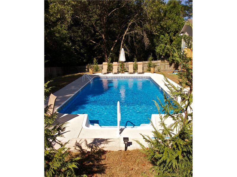 stairs leading into pool with lounge chairs on decking