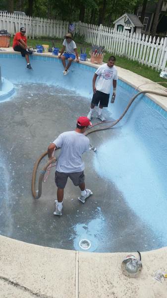 worker spraying replaster in pool