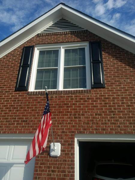 double window with black shutters above garage