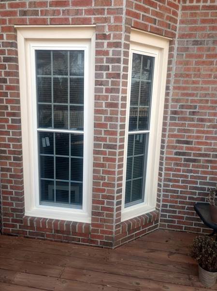 2 single windows one on each corner of brick house