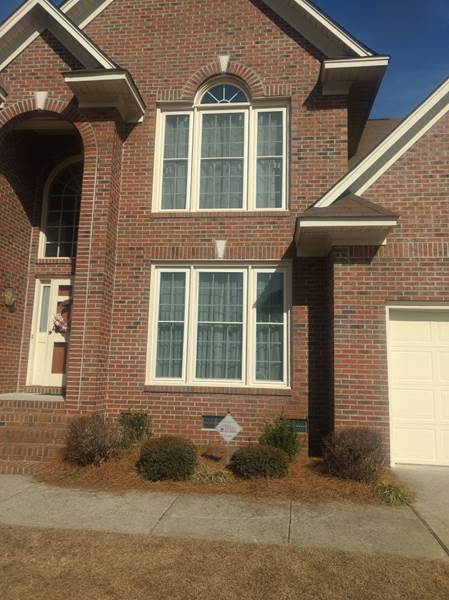 2 triple windows on front of brick house
