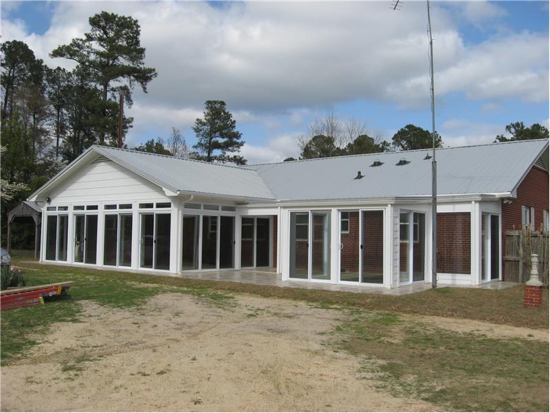 white sunroom addtion on back of house