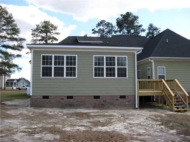 back view of sunroom addition with deck of the side