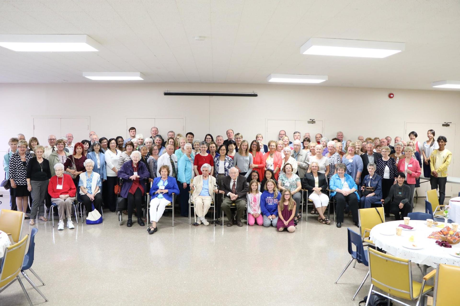 a large group of people are posing for a picture in a room .