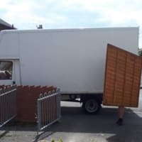 man moving fence from white van