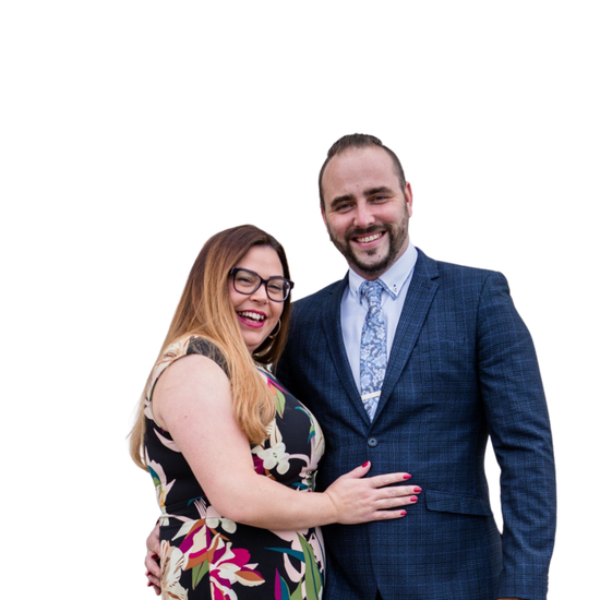 A man in a suit and tie is standing next to a woman in a dress.
