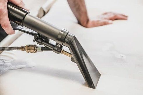 Picture of an upholstery cleaning machine being used on upholstery.