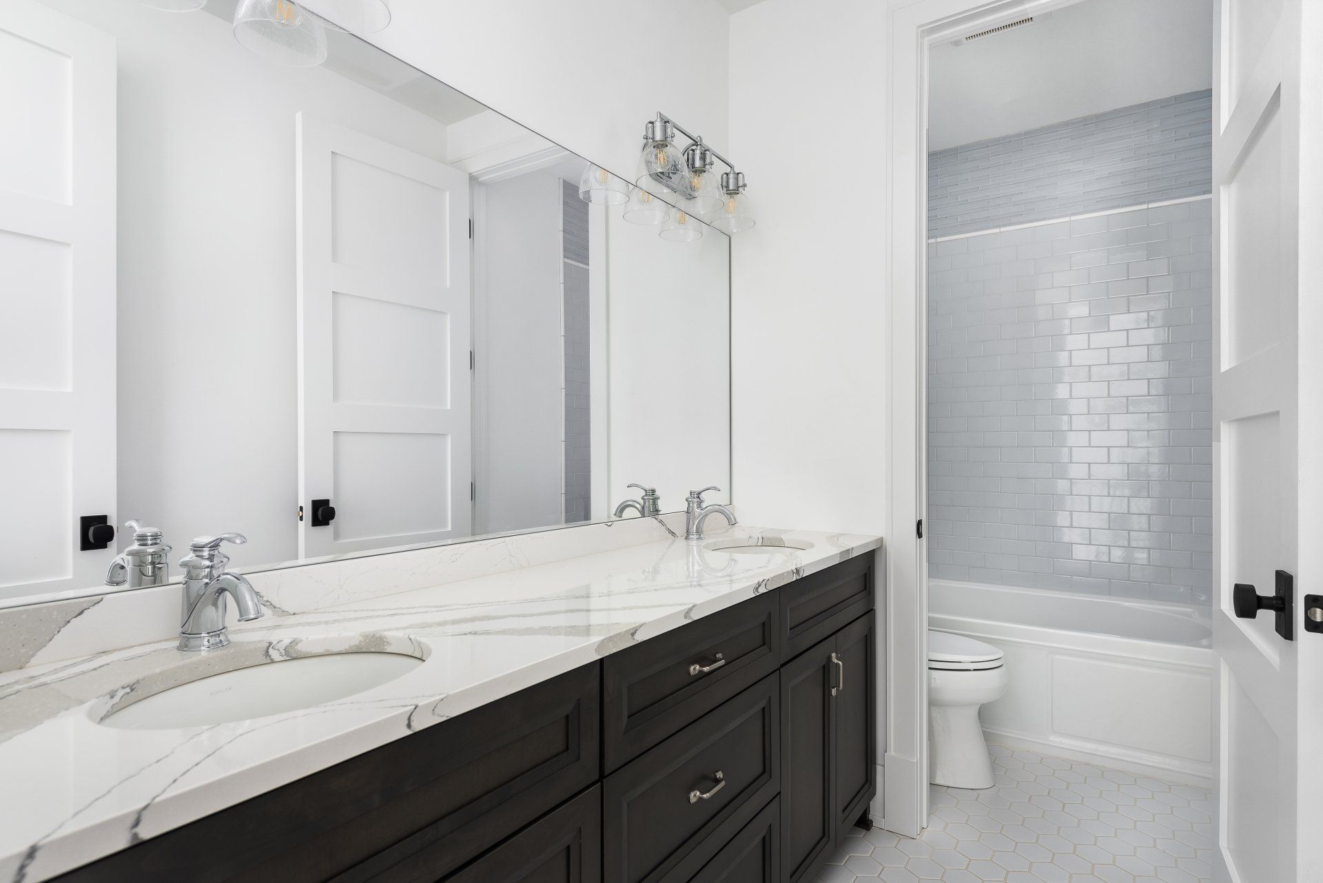 A bathroom with two sinks , a toilet , and a bathtub.