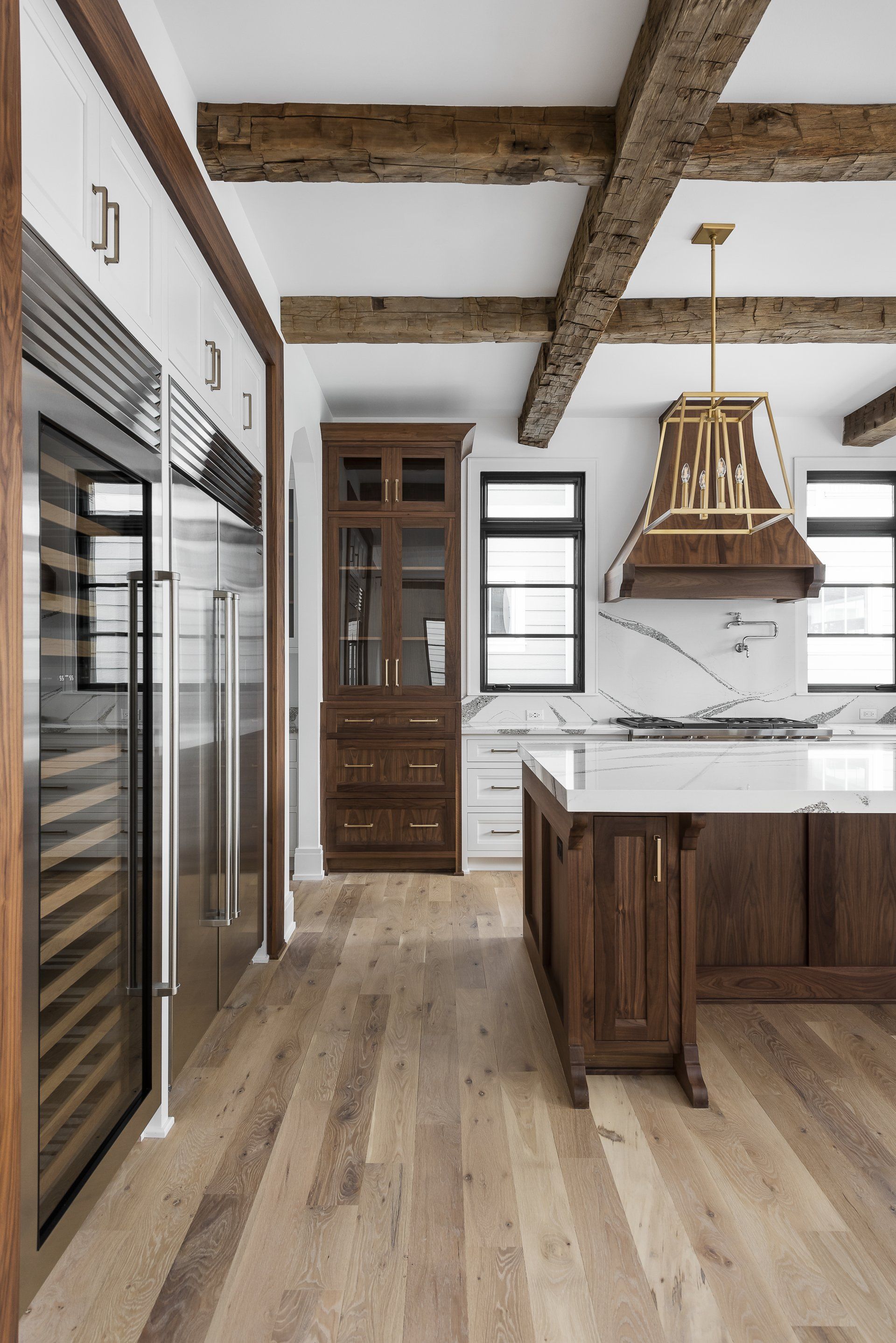 A kitchen with wooden cabinets , stainless steel appliances , and a large island.