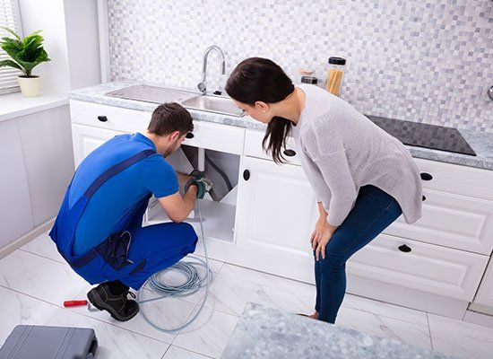 Male Plumber Cleaning Clogged Sink — Hatfield, MA — AM/PM Plumbing & Heating Male Plumber Cleaning Clogged Sink — Hatfield, MA — AM/PM Plumbing & Heating
