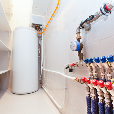Commercial Water Heaters — Person Adjusting Room Heat in Clute, TX Commercial Water Heaters — Person Adjusting Room Heat in Clute, TX