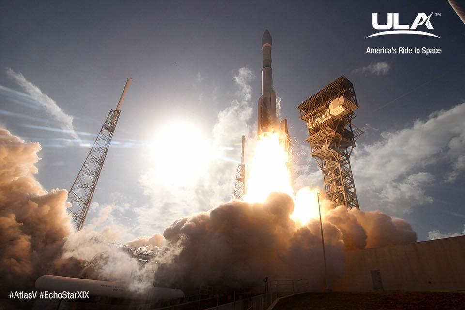 A rocket launches, emitting a bright flame and smoke, with the sun shining brightly in the background.