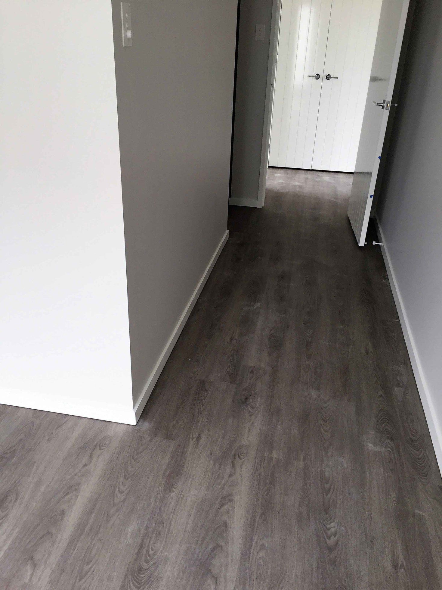 brown floor with white walls and open door