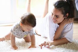 Mother Reading A Book To Her Baby