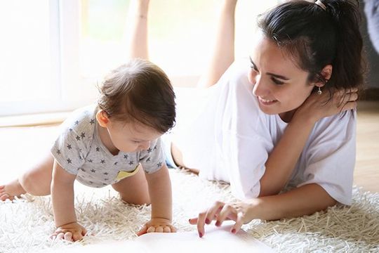 Mother Reading A Book To Her Baby