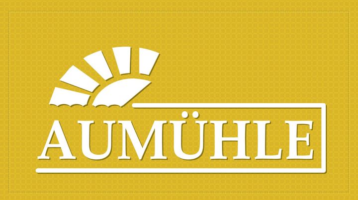 Logo für Aumühle, eine weiße, sonnenähnliche Form über dem Namen in einem Kasten auf gelbem Hintergrund.