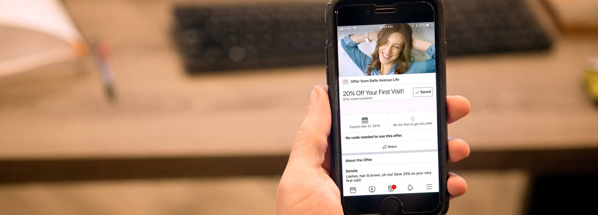 A person is holding a cell phone with a picture of a woman on the screen