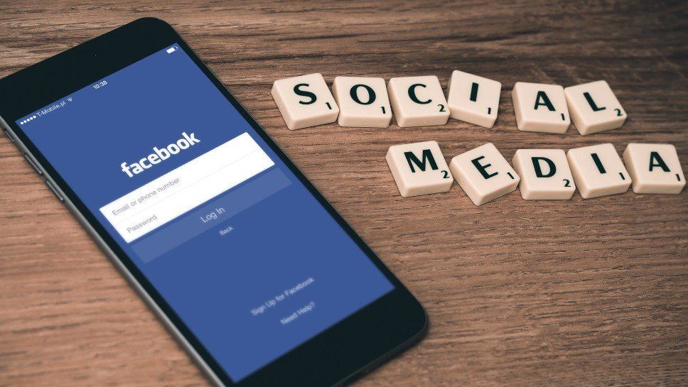 A cell phone with the word facebook on the screen